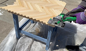 Man cutting off edges of end tables